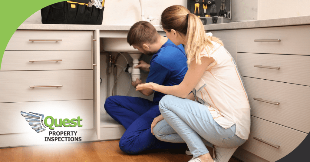 Home inspector checking under-sink plumbing