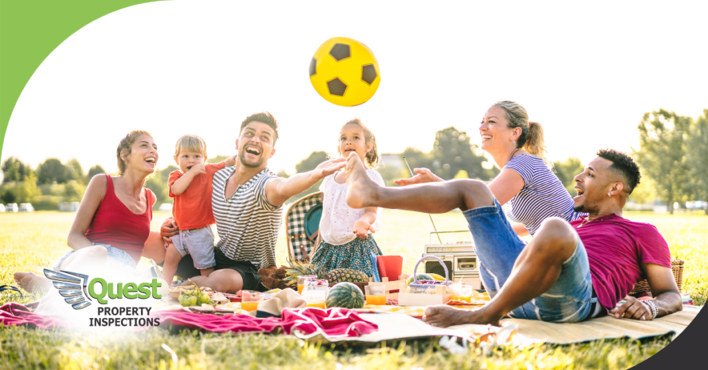 Family tossing soccer ball at sunny picnic