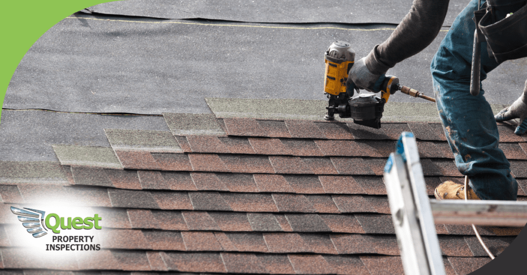 Worker securing asphalt shingles with pneumatic nailer